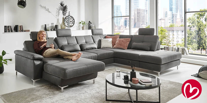 Frau auf grauem Sofa mit Liegefunktion